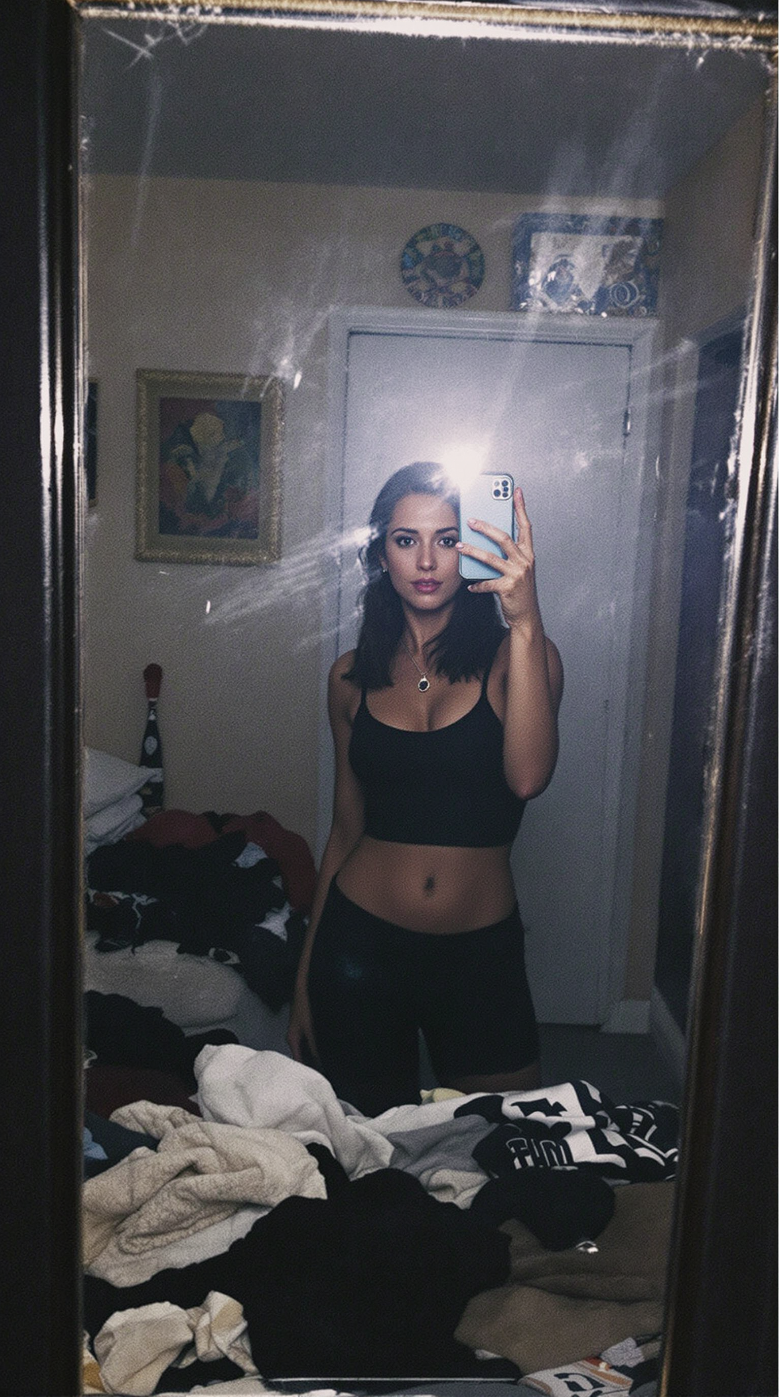 FLUX prompt: woman stands in front of a mirror, capturing a selfie. The image quality is grai...