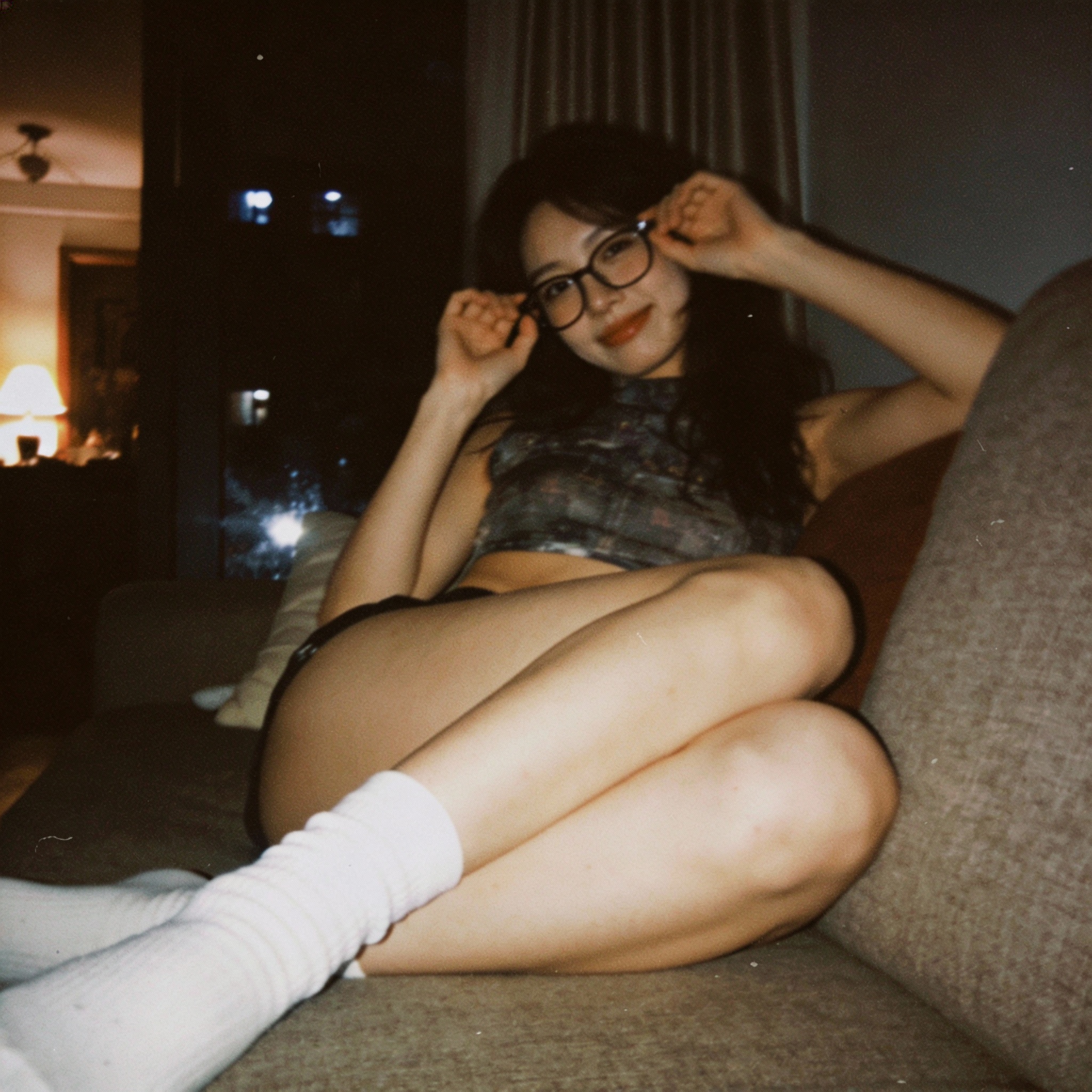 Seedream 4 prompt: looking at me,a sloppy snapshot. Sitting on a couch at night teasing, mini top a...